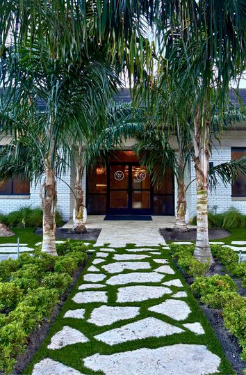 Palm-lined stone walkway leading to the entrance of The Office at Ponte Vedra Beach